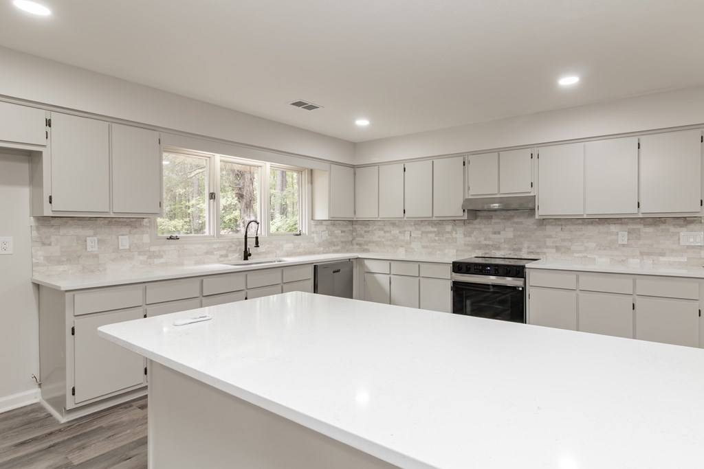 8585 McKee Road Upatoi, GA 31829 - Photo 9 of 62 a kitchen with granite countertop white cabinets and white appliances