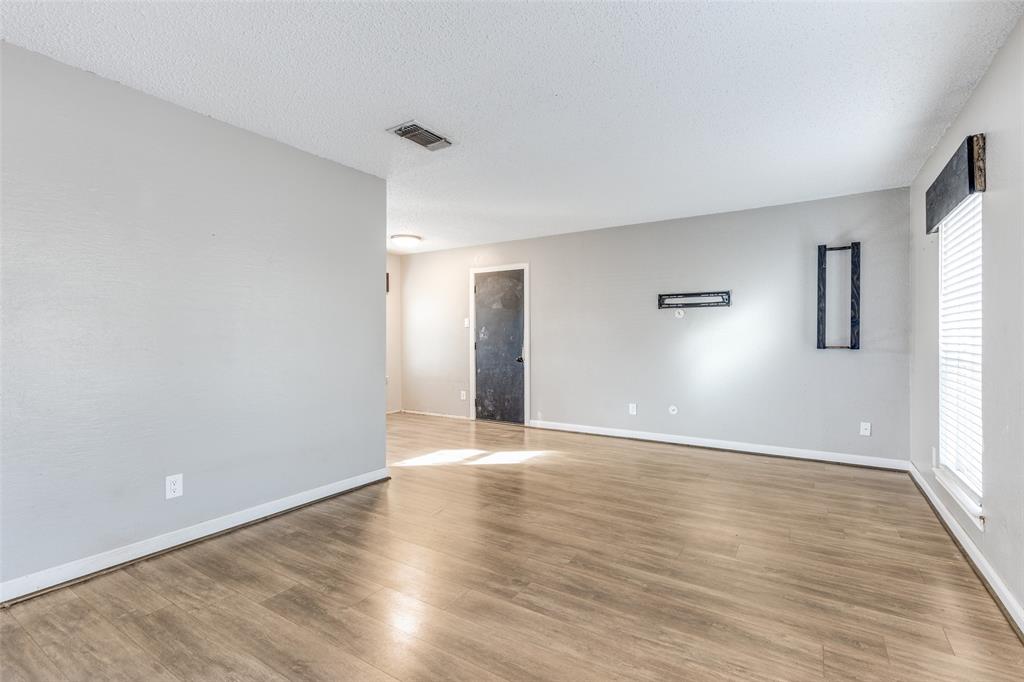 500 Lake Crest Parkway Azle, TX 76020 - Photo 11 of 23 a view of an empty room with wooden floor and a window