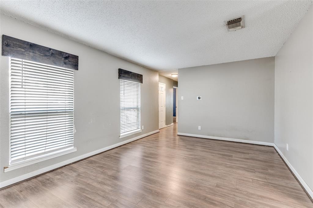500 Lake Crest Parkway Azle, TX 76020 - Photo 7 of 23 a view of an empty room with wooden floor and a window
