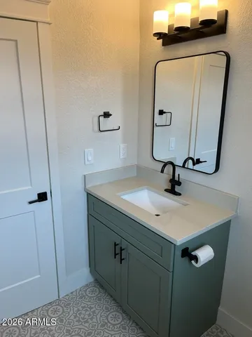 a bathroom with a sink vanity and mirror