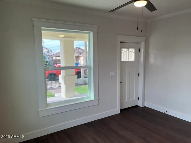 an empty room with wooden floor and windows