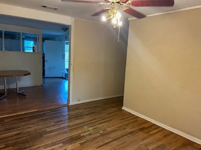 a view of empty room with wooden floor