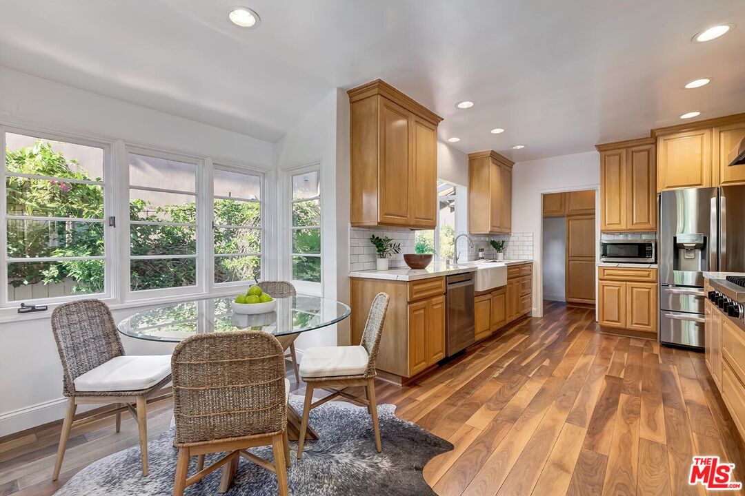 384 North Bonhill Road Los Angeles, CA 90049 - Photo 11 of 32 a kitchen with sink a refrigerator and chairs