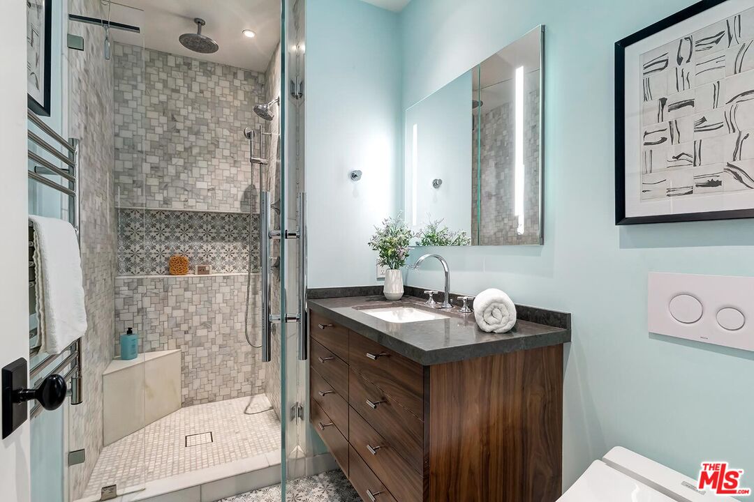 384 North Bonhill Road Los Angeles, CA 90049 - Photo 24 of 32 a bathroom with a granite countertop sink a mirror a vanity and a shower