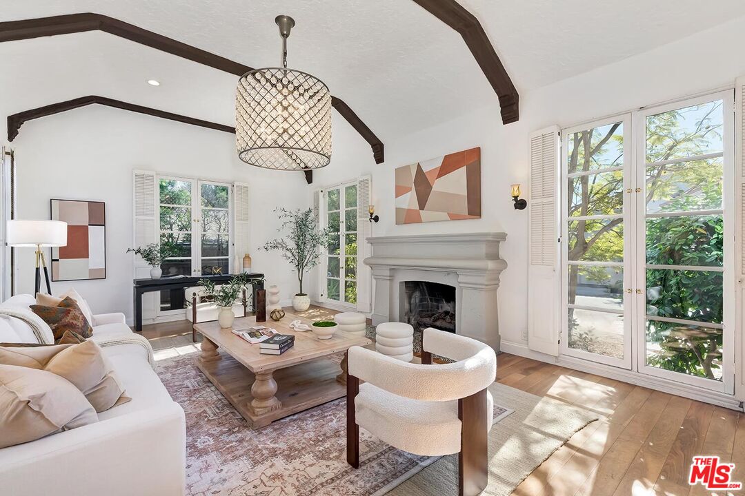 384 North Bonhill Road Los Angeles, CA 90049 - Photo 5 of 32 a living room with furniture a fireplace and a floor to ceiling window