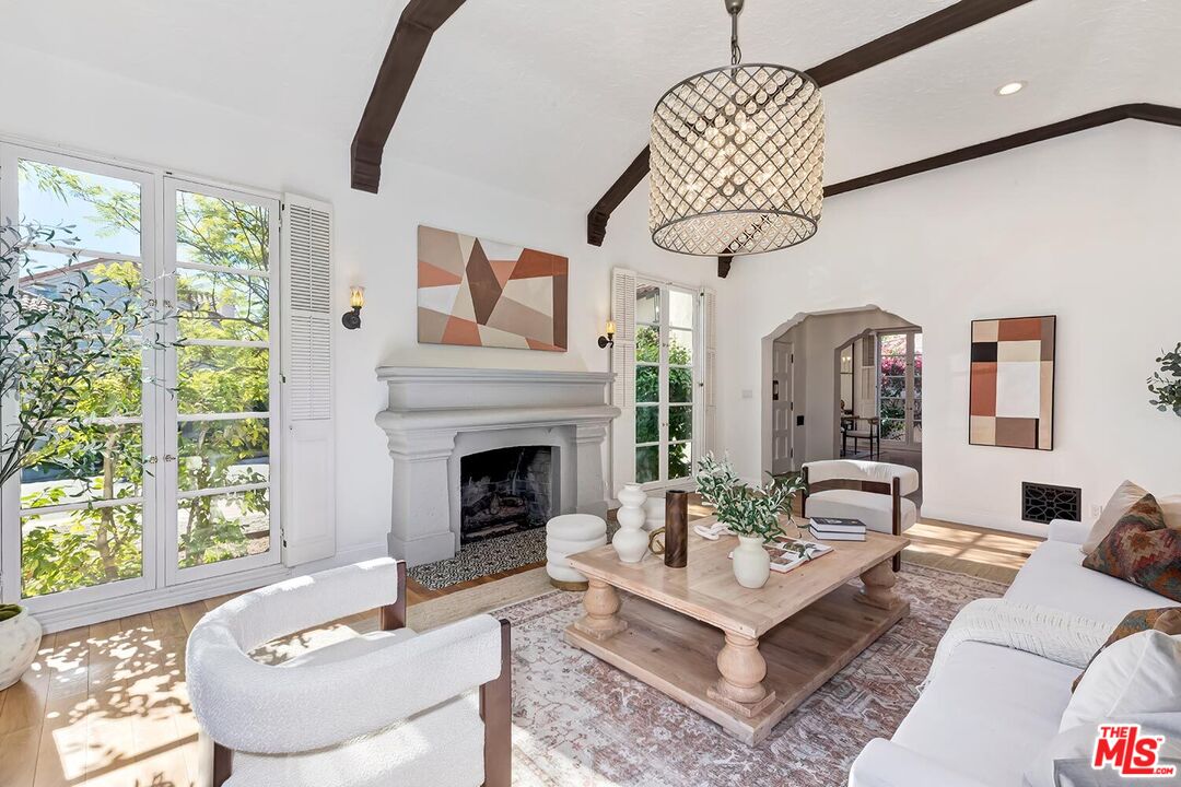 384 North Bonhill Road Los Angeles, CA 90049 - Photo 7 of 32 a living room with furniture a chandelier and a fireplace