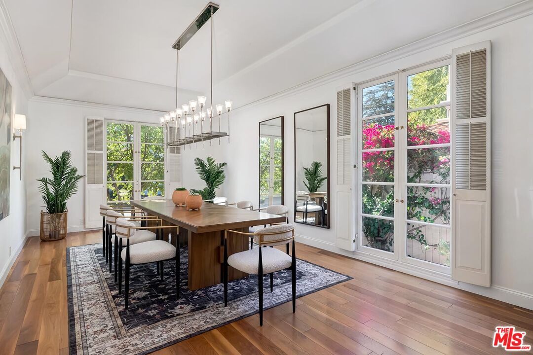 384 North Bonhill Road Los Angeles, CA 90049 - Photo 8 of 32 a view of a dining room with furniture a chandelier and wooden floor