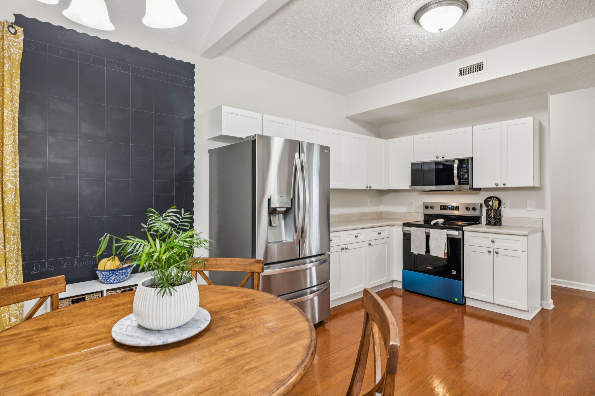 1443 Bern Drive Spring Hill, TN 37174 - Photo 27 of 64 a kitchen with stainless steel appliances kitchen island granite countertop a refrigerator a stove a sink and a dining table with wooden floor