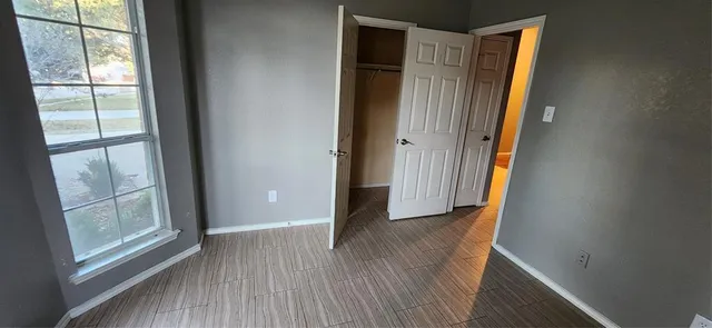 a view of a room with wooden floor and windows