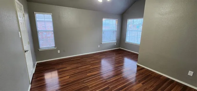 a view of a room with wooden floor and window