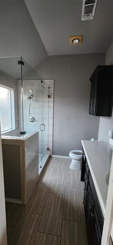 a bathroom with a sink a toilet a mirror and shower