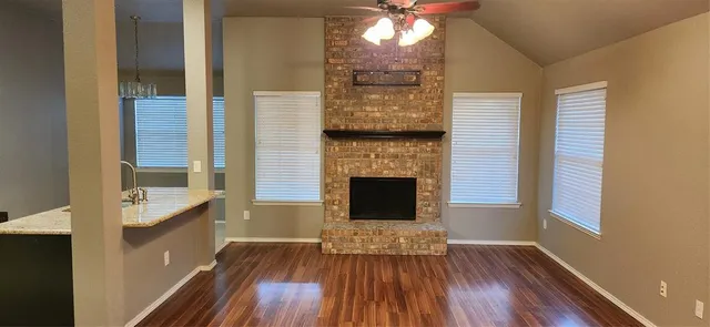 a living room with a fireplace and wooden floor