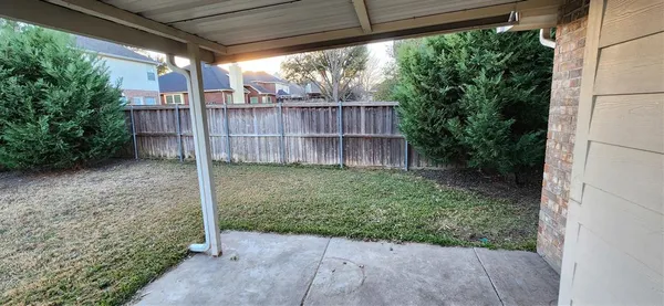 a view of a yard with wooden fence