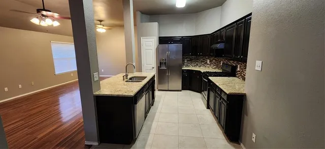 a kitchen with stainless steel appliances granite countertop a sink and a stove