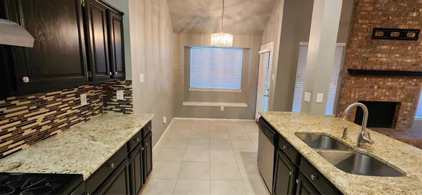 a kitchen with a granite countertop sink a stove and a refrigerator