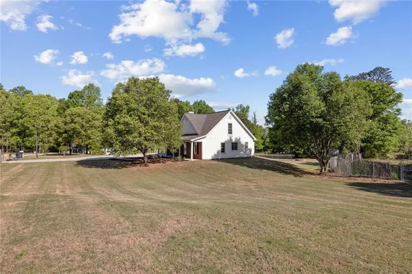 a view of an house with backyard and a tree