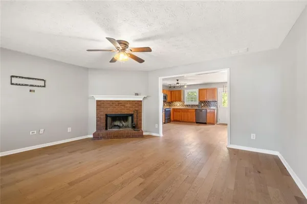 a view of an empty room with a fireplace and a window