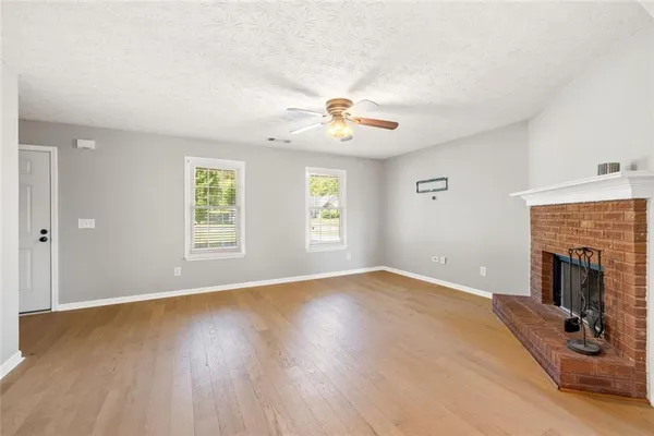 an empty room with windows and fireplace