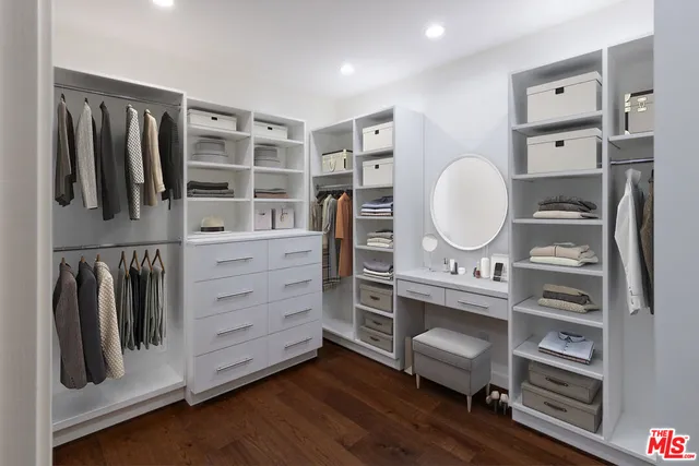 a view of walk in closet with clothes and shoes