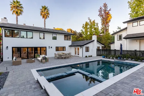 a view of a house with pool and sitting area