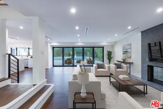 a living room with furniture fireplace and large windows