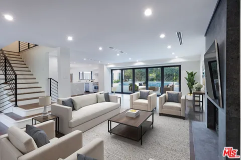 a living room with furniture fireplace and balcony