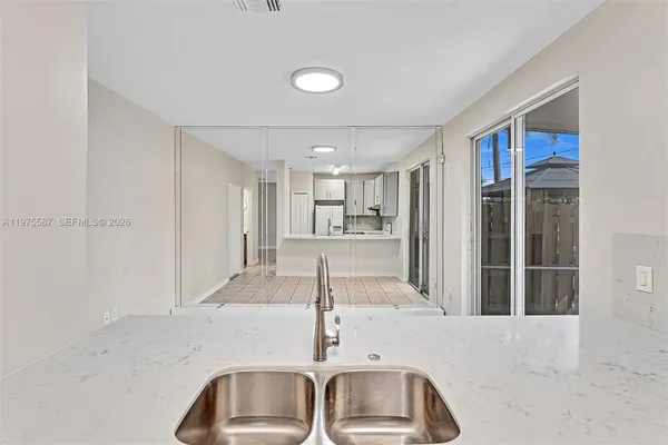 a kitchen with granite countertop a sink and a refrigerator