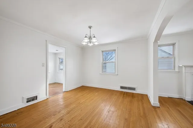 a view of a room with wooden floor and chandelier