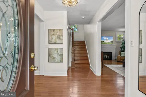 a kitchen with stainless steel appliances a stove a sink a microwave a refrigerator and a dining table