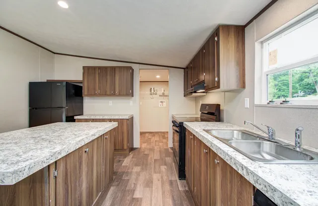 a kitchen with stainless steel appliances granite countertop a sink stove microwave refrigerator and wooden cabinets