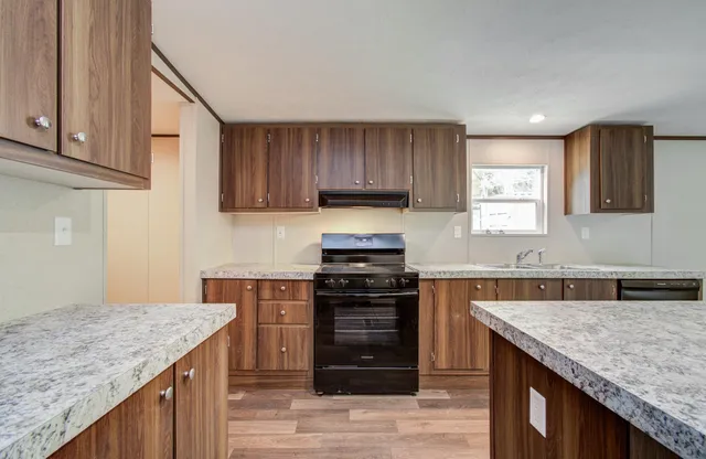 a kitchen with granite countertop wooden cabinets and a stove top oven