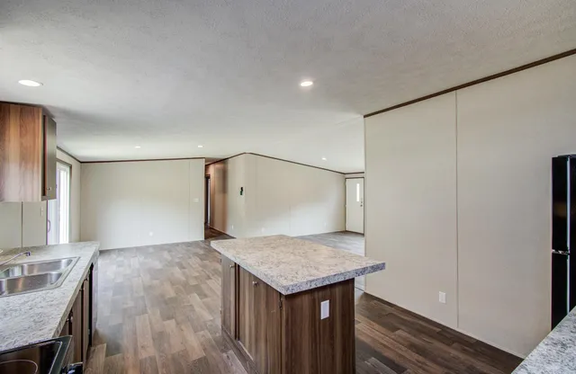 a kitchen with granite countertop sink stove and refrigerator