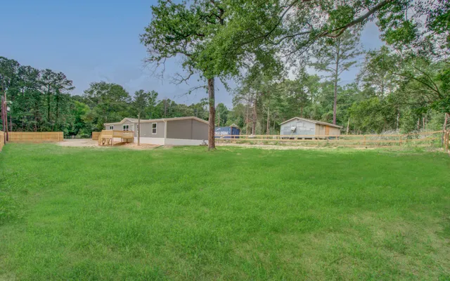 a view of a house with backyard and sitting area