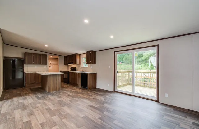 a large kitchen with stainless steel appliances granite countertop a large counter top and a wooden floors