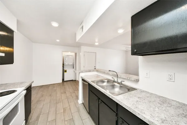 a kitchen with a sink dishwasher and a stove with wooden floor