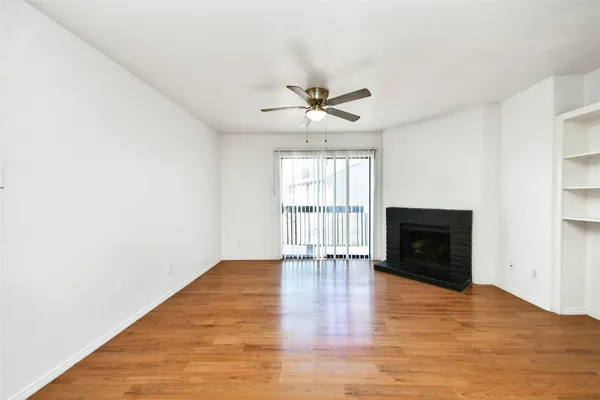 a view of an empty room with a window and a fireplace