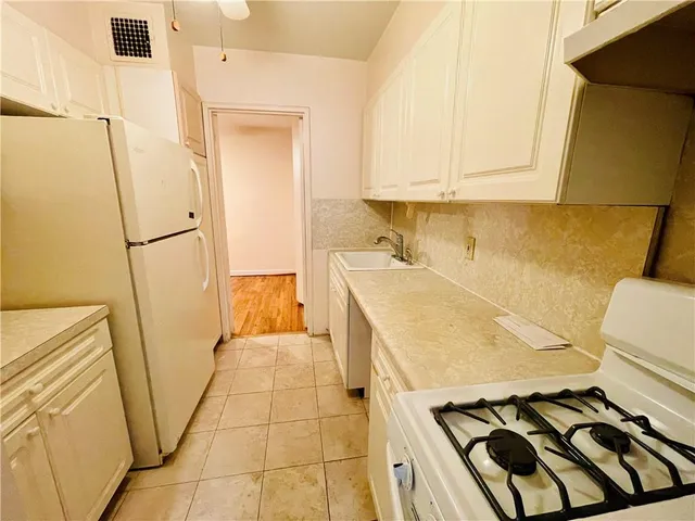 a kitchen with a white stove top oven and sink