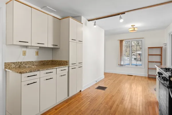 a kitchen with granite countertop white cabinets and white appliances