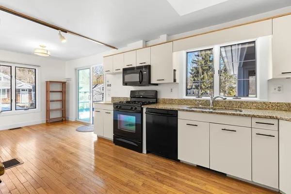 a kitchen with granite countertop a stove top oven and refrigerator
