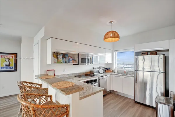 a kitchen with stainless steel appliances granite countertop a sink and a refrigerator