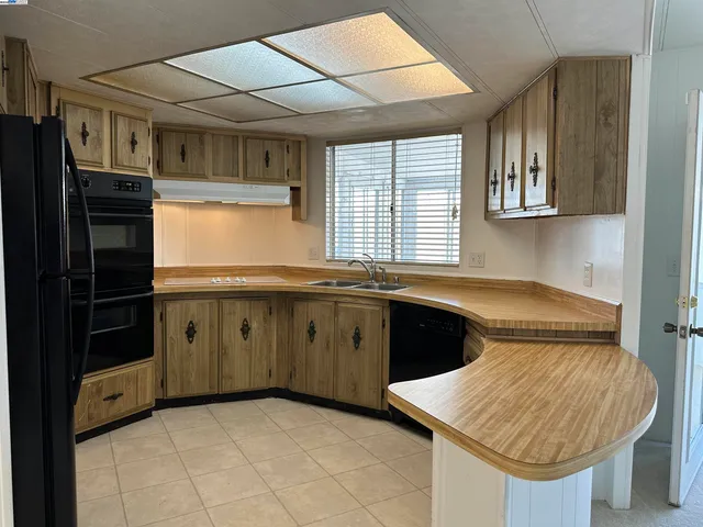 a kitchen with stainless steel appliances granite countertop a refrigerator stove and sink