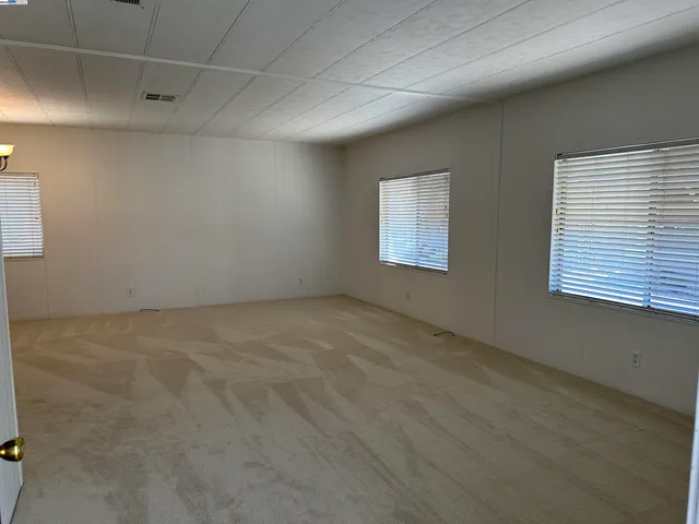 an empty room with windows and cabinet