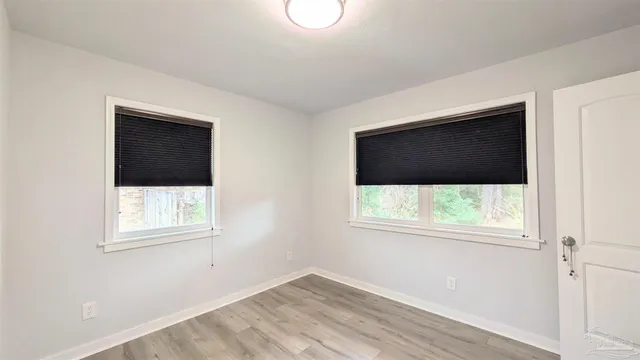an empty room with a window and a flat screen tv