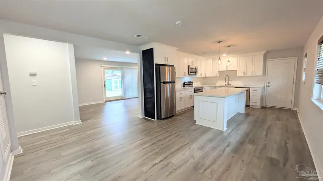 a kitchen with stainless steel appliances a refrigerator and wooden floor