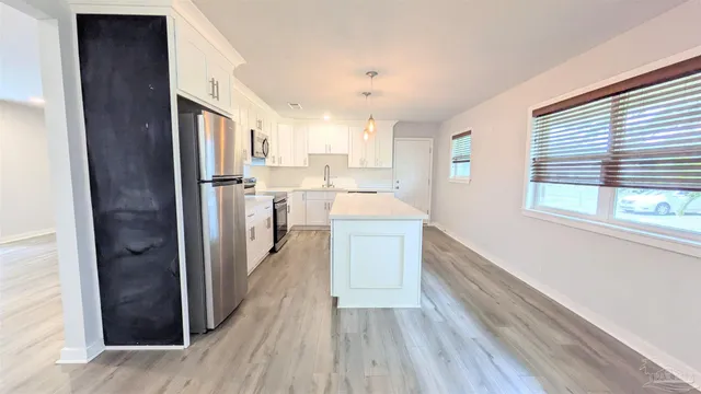 a kitchen with refrigerator cabinets and wooden floor
