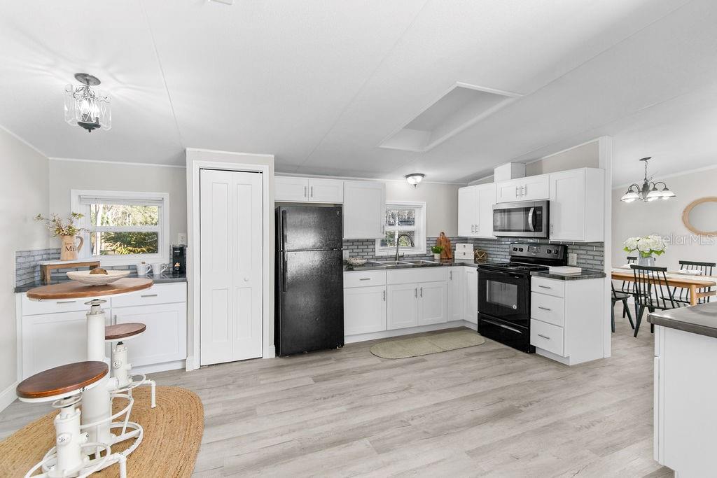 18137 Hollister Road Orlando, FL 32820 - Photo 3 of 27 a kitchen with stainless steel appliances kitchen island granite countertop a refrigerator and stove top oven