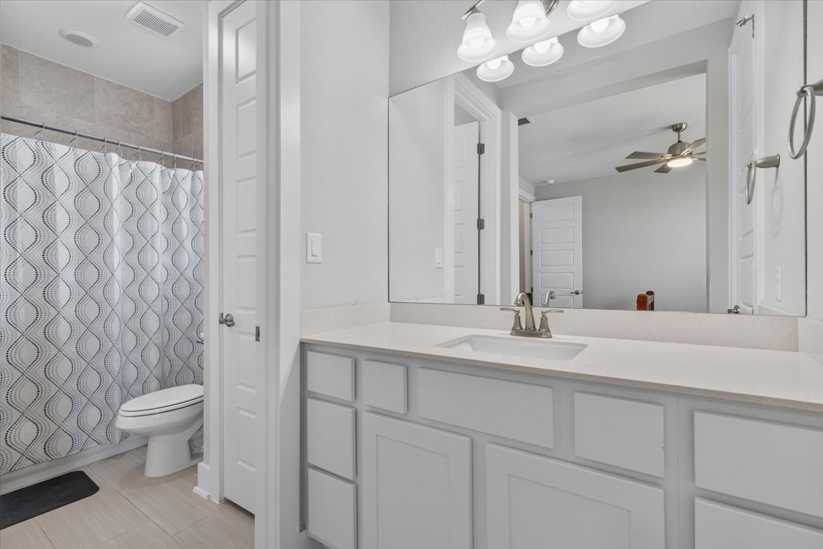 320 Raptor Beak Way Cedar Creek, TX 78612 - Photo 33 of 40 A well-lit bathroom with a bright vanity and a tiled shower area.