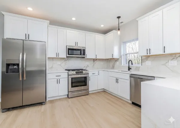 a kitchen with cabinets stainless steel appliances and a counter space