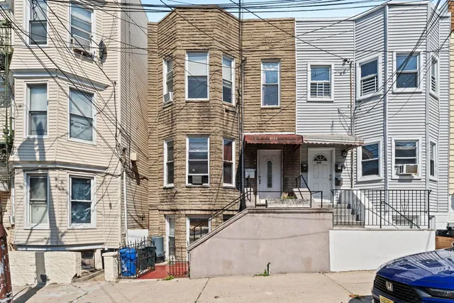 a front view of a building and car parked