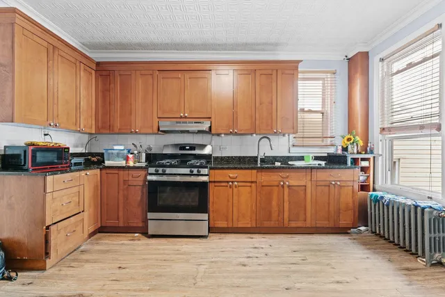 a kitchen with stainless steel appliances granite countertop a stove a sink and a microwave